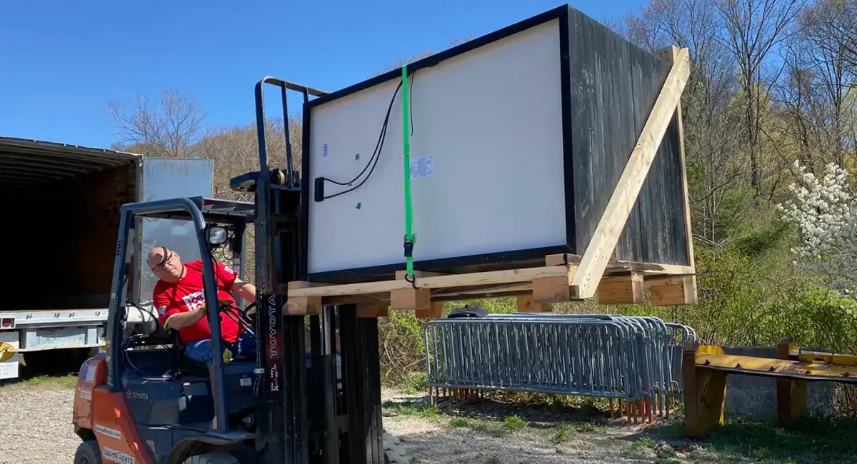 Mike Beach, a driver for OSJL, moves a pallet of solar panels into the OSJL tractor-trailer. The solar panels will help power 25 tiny homes in Erie, Pennsylvania as part of Project Freedom Villages’ tiny homes project for veterans without permanent housing.