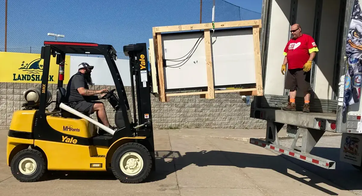 Volunteers offload solar panels in Erie, Pennsylvania. The solar panels were delivered from Foxboro, Massachusetts, and will help power 25 tiny homes as part of Project Freedom Villages’ tiny homes project for veterans without permanent housing.