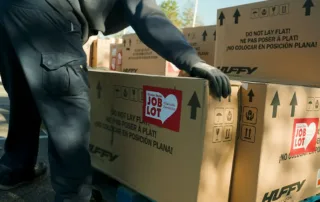 Boxes of Huffy bicycles are unloaded from Ocean State Job Lot tractor trailers