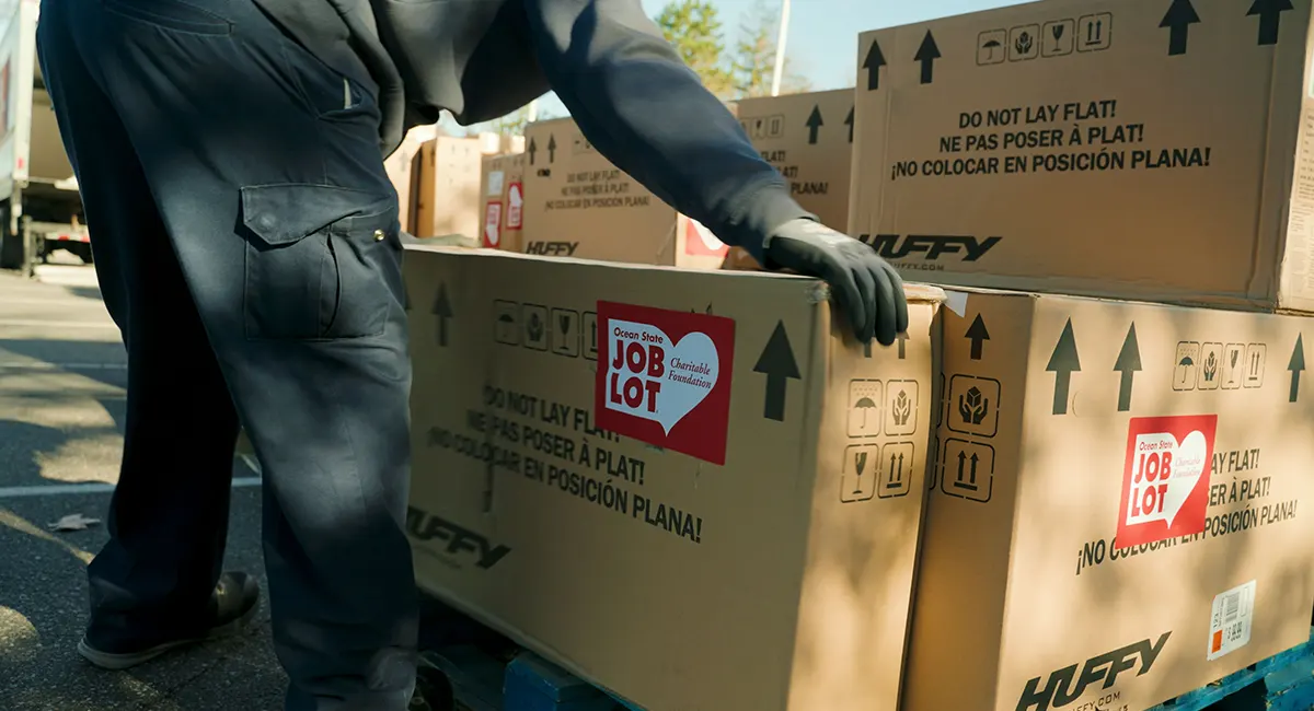 Boxes of Huffy bicycles are unloaded from Ocean State Job Lot tractor trailers