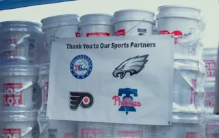 Ocean State Job Lot pallet of Kits or Kindness with a sign on it form participating professional Philadelphia sports teams.