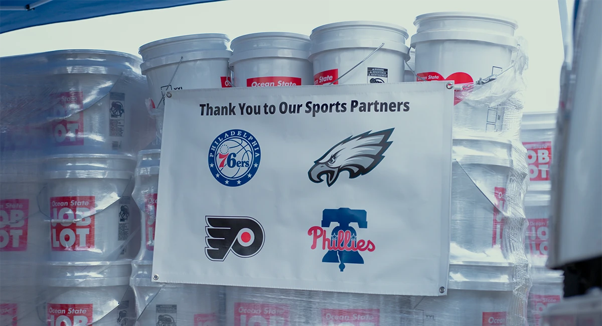 Ocean State Job Lot pallet of Kits or Kindness with a sign on it form participating professional Philadelphia sports teams.