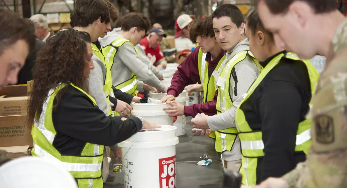 Ocean State Job Lot associates and volunteers helping stuff buckets or kindness for veterans in need.